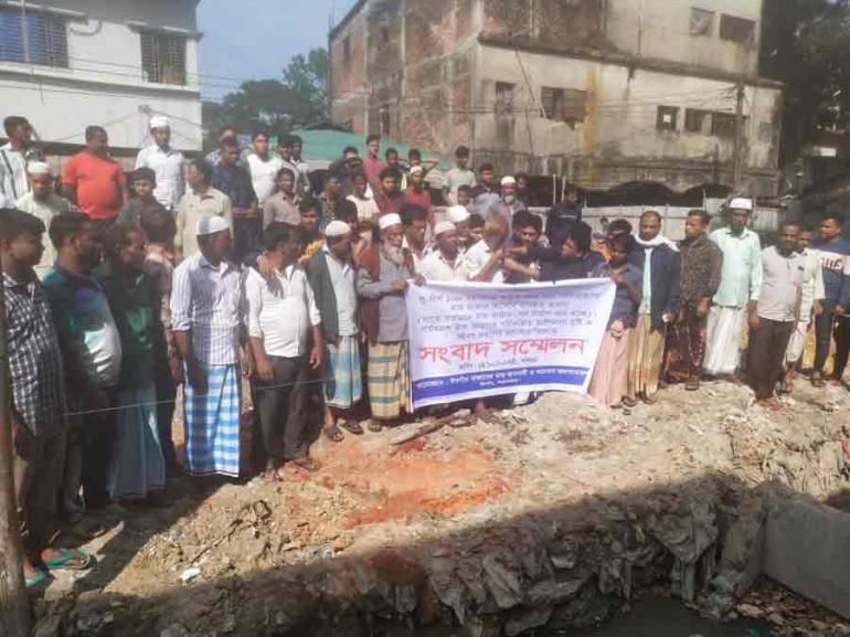 রাতের আধাঁরে পাকা ব্যাজ ঢালাইয়ের জন্য খননকৃত গর্ত ও নীচে ব্যবসায়ীদের আন্দোলন)